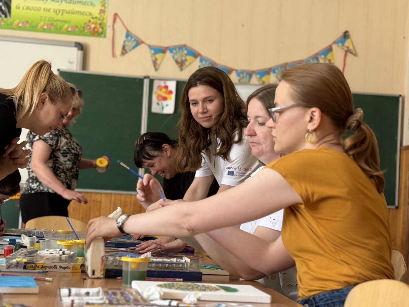 Вчителі на арттерапевтичному занятті малюють за столом